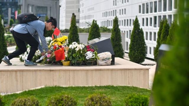 2024年5月7日星期二，塞尔维亚贝尔格莱德，在中国国家主席习近平进行国事访问之前，一名游客在中国大使馆旧址的纪念碑前献花。